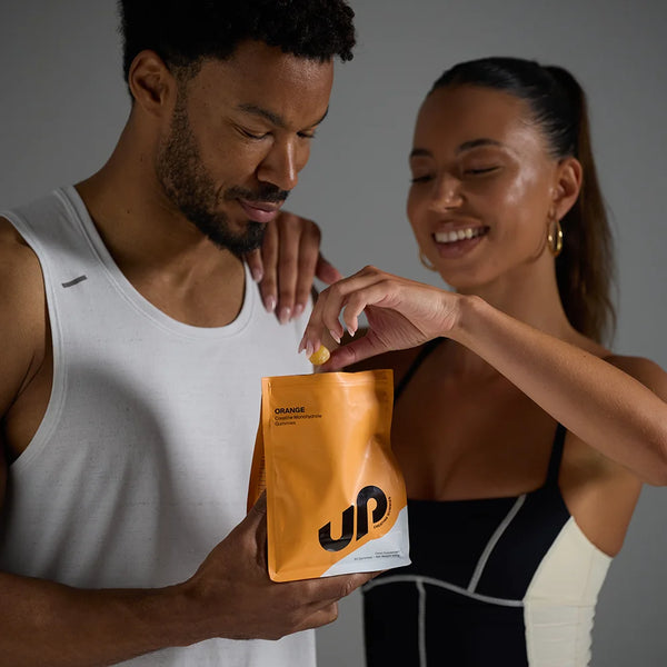 Man and woman holding a supplement package with a brand logo