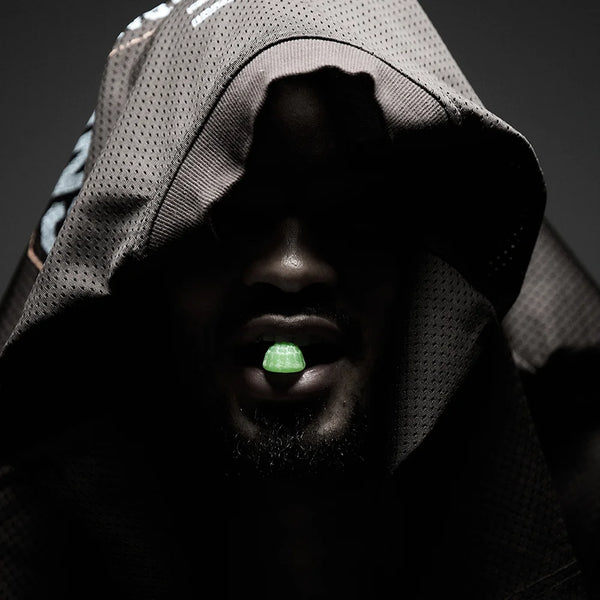 Person wearing a hooded garment eating a gummy