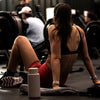 A woman sitting on the floor post workout 
