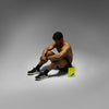 Man sitting on a gray background with a yellow box in front of him